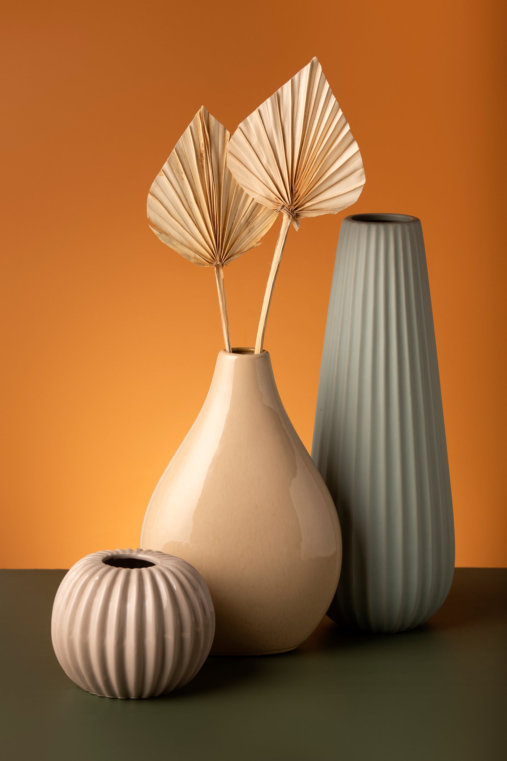 Three decorative vases with a beige and brown background